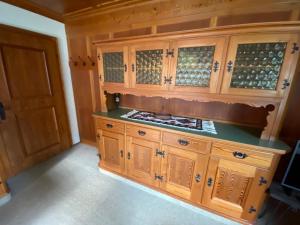 a kitchen with wooden cabinets with glass doors at Ferienhaus Greti Ehrwald in Ehrwald