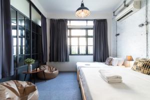 a hotel room with two beds and a table at Ombra House No. 21-24 in Chiang Mai