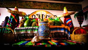 a table with a vase and baskets of fruit and vegetables at Hotel Montetaxco in Taxco de Alarcón