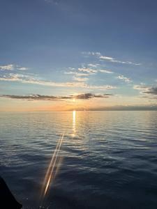 a view of the sun setting over the water at Darhan Guest House in Darkan +3 photos