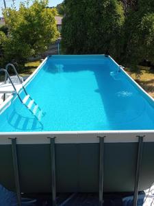 a large swimming pool with a chair next to it at La petite histoire in Brive-la-Gaillarde