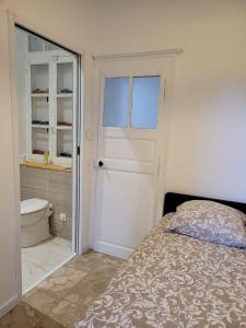 a bedroom with a bed and a bathroom with a toilet at Chez Rémi in Écommoy