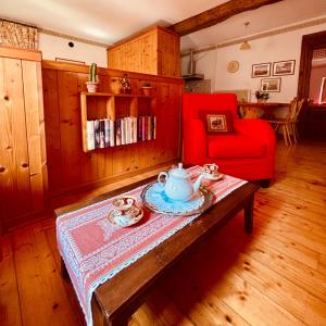 a living room with a coffee table and a red chair at BaBi in Cison di Valmarino
