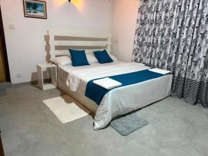 a bedroom with a large bed with blue pillows at Green Villa Midigama in Midigama East