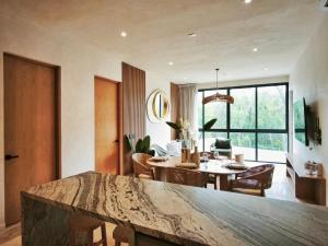 a dining room and living room with a table and chairs at Oniric Condo Tulum in Tulum