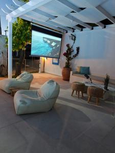 a living room with couches and a large screen at Astre&Jeanne suites in Sozopoli