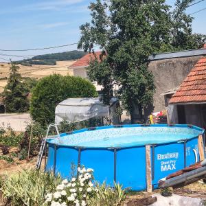 a blue tub in a yard next to a house at Gîte des 3 Suissesses in Saint-Paul