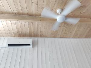 a ceiling fan in a room with a window at Chalet Ø2 - lumineux et climatisé - proche plage in La Brée-les-Bains