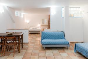 a living room with a table and a blue chair at Afroditi Pansion in Agios Nikitas