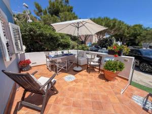 eine Terrasse mit Tisch, Sonnenschirm und Stühlen in der Unterkunft L'Oleandro Bianco in Ponza