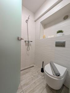 a white bathroom with a toilet and a shower at Cozy Studio in Downtown Sesvete in Sesvete +6 photos