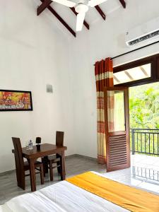 a bedroom with a table and a bed and a window at Aurelia Grand Hotel in Kitulgala