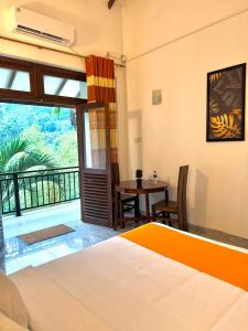 a bedroom with a bed and a table and a balcony at Aurelia Grand Hotel in Kitulgala +22 photos