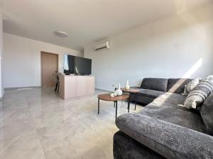 a living room with a couch and a tv at Flamingo Vacation Rentals in Paphos
