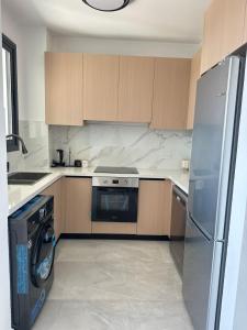a kitchen with a stainless steel refrigerator and a dishwasher at Flamingo Vacation Rentals in Paphos