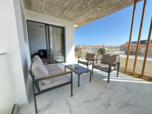 a patio with two chairs and a table and windows at Flamingo Vacation Rentals in Paphos