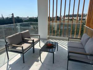 a balcony with two chairs and a table on a balcony at Flamingo Vacation Rentals in Paphos +1 photo