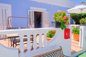 ein Balkon mit weißem Geländer und ein Tisch mit Blumen in der Unterkunft L'Oleandro Bianco in Ponza + 17 Fotos