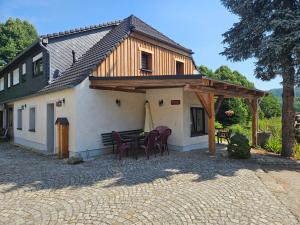 a patio with a table and chairs in front of a house at Ferienwohnungen Familie Gottfried in Schirgiswalde