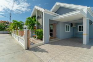 a blue house with a porch and a fence at พลอยพูลวิลล่า ชะอำ 1 Ploy Poolvilla Cha-am 1 in Cha Am