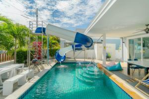 a pool with a water slide in a house at พลอยพูลวิลล่า ชะอำ 1 Ploy Poolvilla Cha-am 1 in Cha Am