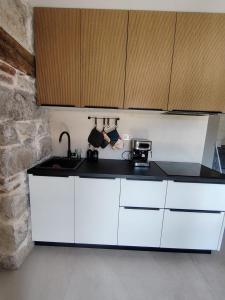 a kitchen with white cabinets and a counter top at VODIČARJEVA HiŠiCA in Grgar