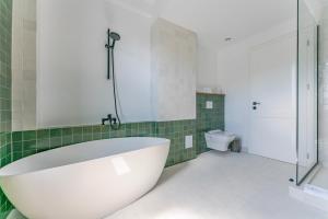 ein Badezimmer mit einer großen Badewanne und einer Toilette in der Unterkunft Vila Core in Rucăr