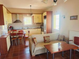 a living room and kitchen with a couch and a table at MELIA Holidays & Living in Epanomi