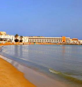 a view of a beach with buildings in the background at Villa Samia in Staoueli