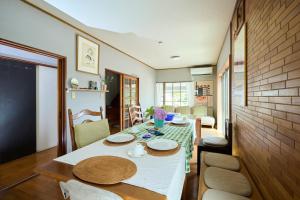 a dining room with a white table and chairs at Miura Base in Miura
