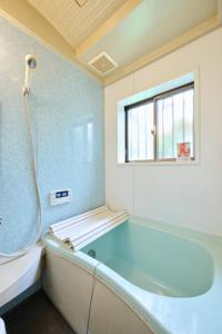 a bath tub in a bathroom with a window at Miura Base in Miura