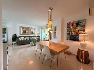 a dining room and living room with a wooden table at Beach Penthouse Apartment in Jávea