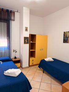 a room with two beds and a yellow cabinet at CASA Di MIRKO in Gallipoli +12 photos