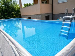 a blue swimming pool with a ladder and a ladder at M&M Trebinje in Trebinje