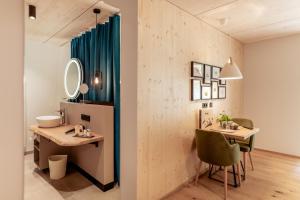 a bathroom with a vanity and a sink and a mirror at Boutique Hotel LechZeit in Elmen +51 photos