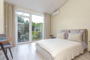 a bedroom with a bed and a large window at 4rest in Palanga