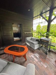 a patio with a couch and a table and a piano at Guest House Villa Arkadia in Warsaw