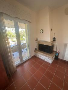 a living room with a fireplace and a patio at MELIA Holidays & Living in Epanomi