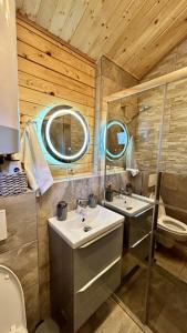 a bathroom with two sinks and a toilet at Elysium House in Băile Herculane