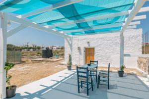 a patio with a table and chairs on it at Paraspori in Adamantas