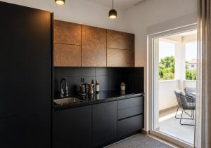 a kitchen with black cabinets and a window at Aksa Residences in Vir