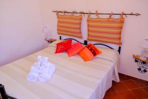 ein Schlafzimmer mit einem Bett und zwei Paar Hausschuhen in der Unterkunft L'Oleandro Bianco in Ponza