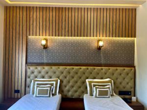 two beds sitting next to each other in a room at Shakti Resort in Behror +3 photos