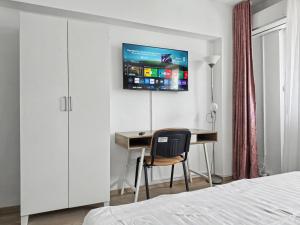 a bedroom with a desk and a tv on a wall at Konstanzer Stefan 15 - Old Town Apt - Palas Mall - AC in Iaşi