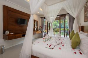 a bedroom with a bed with roses on it at Ubud Tropical Garden in Ubud