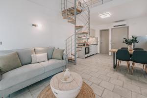 a living room with a couch and a spiral stair at Luminis Residence by All about Paxos in Gaios