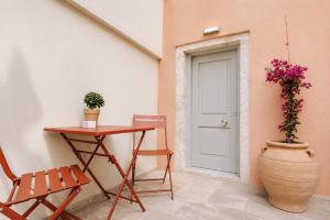 a table and a chair next to a door at Luminis Residence by All about Paxos in Gaios