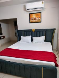 a bed in a room with a red blanket at Royal Residency in Vākalapūdi +15 photos