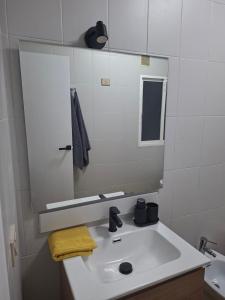 a bathroom with a white sink and a mirror at Piso 4 dormitorios playa sada in Sada