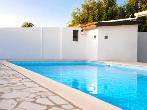 a swimming pool next to a white fence at Casa del Carrubo con Piscina, relax in campagna vicino al mare in Santa Croce Camerina